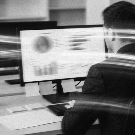 Setting up a business dashboard on a monitor beside printed process notes